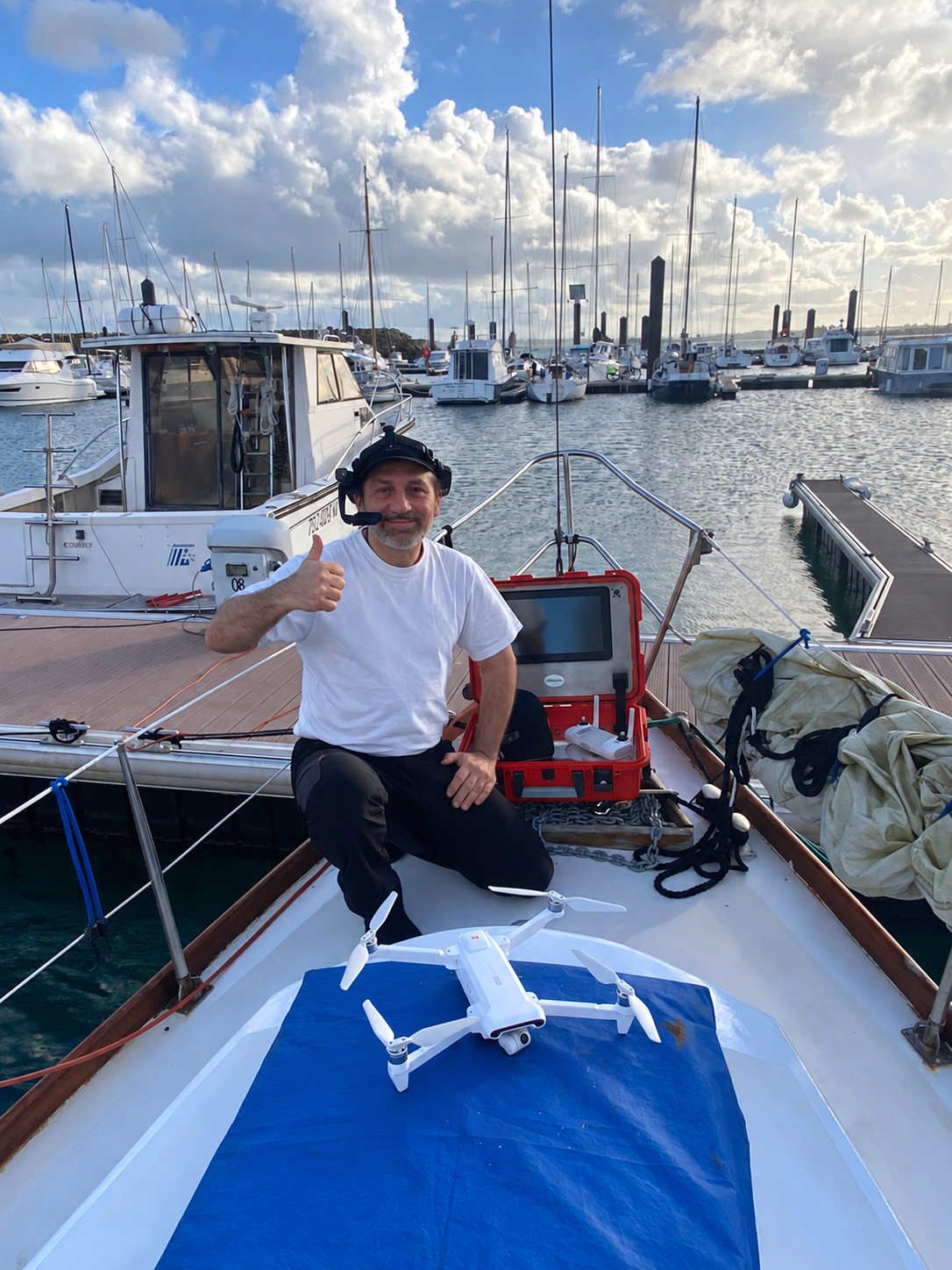 Person mit Headset, mobilem Koffer und Drohne auf einem Boot